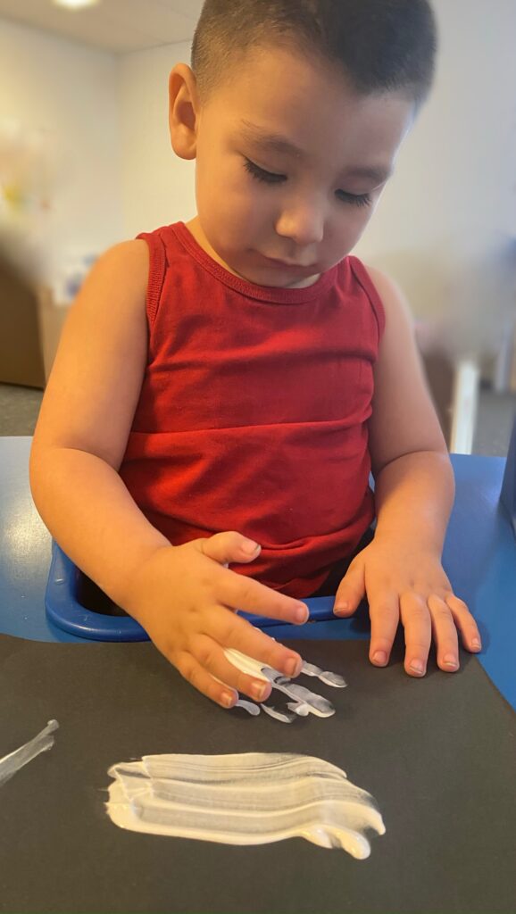 boy in daycare, playing with foam to make foam art.